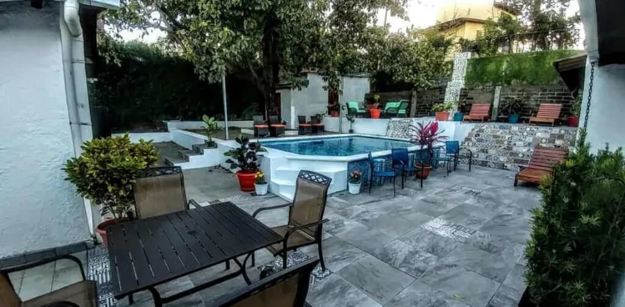 The pool and the tiled garden terraces with tables and chairs